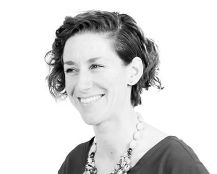 A black and white headshot photograph of a smiling woman