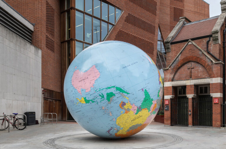 A large globe sitting in front of a building