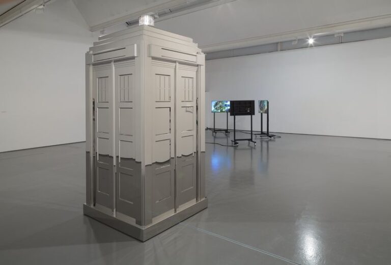 A room with a tv and a statue of a TARDIS in it